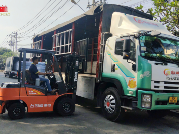 Xe nâng bốc xếp hàng hóa lên xe tải cánh dơi của Vận tải Phan Khánh.